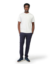 Man wearing a white t-shirt and navy pants on a white background