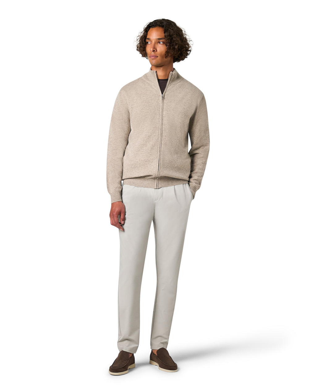 Man wearing a beige zip-up sweater and light gray pants 