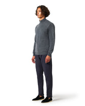 Man wearing a gray sweater and dark pants