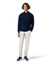 Man wearing a navy blue jacket and white pants