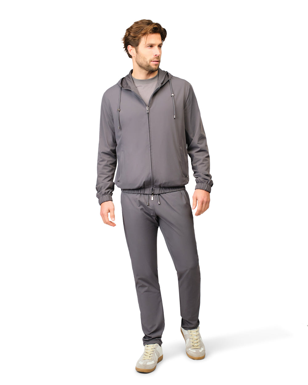 Man wearing a gray tracksuit on a white background