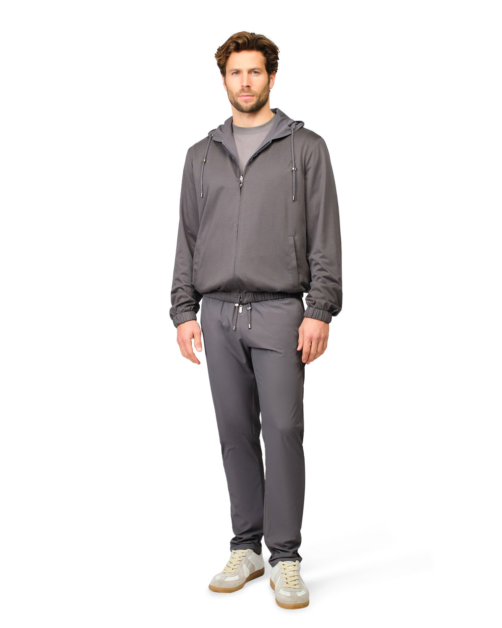 Man wearing a gray tracksuit on a white background