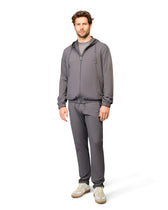 Man wearing a gray tracksuit on a white background