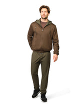 Man wearing a brown jacket and green pants on a white background