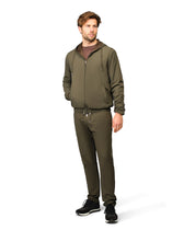 Man wearing an olive green tracksuit on a white background