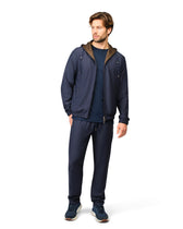 Man wearing a navy tracksuit with a brown hood on a white background