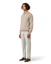 Man wearing a beige sweater and light gray pants