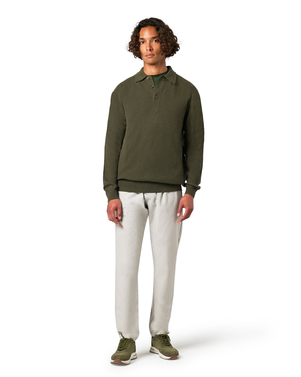 Man wearing a green long-sleeve shirt and white pants 