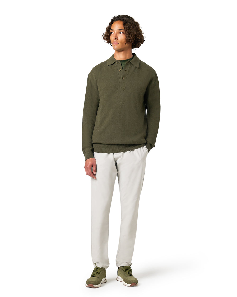 Man wearing a green long-sleeve shirt and white pants 