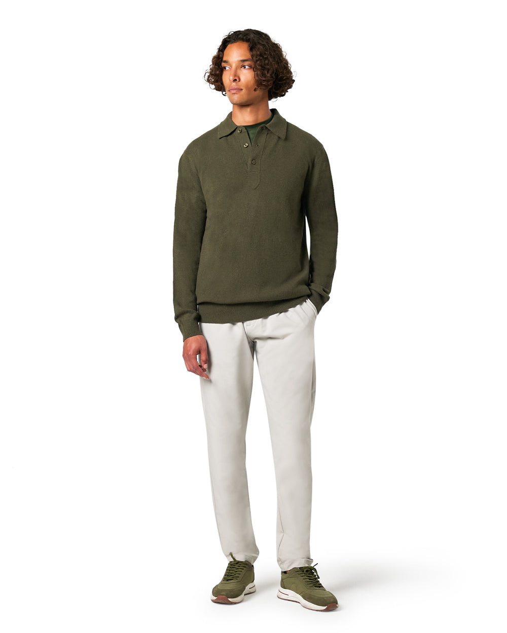 Man wearing a green long-sleeve shirt and white pants 