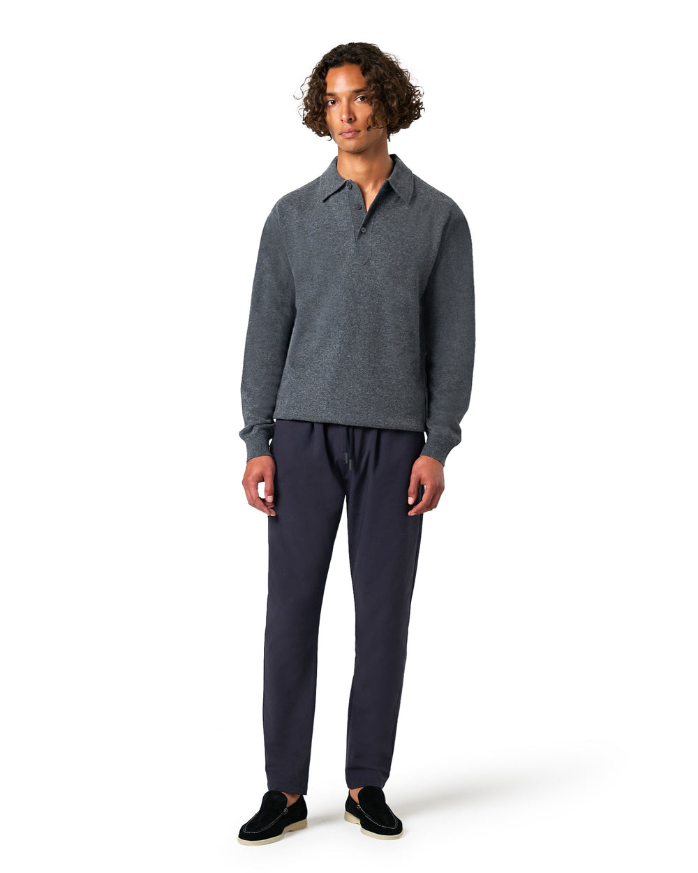Man wearing a gray sweater and dark pants 