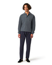 Man wearing a gray sweater and dark pants 