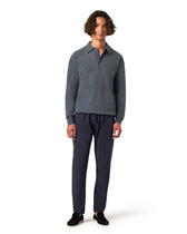 Man wearing a gray sweater and dark pants 