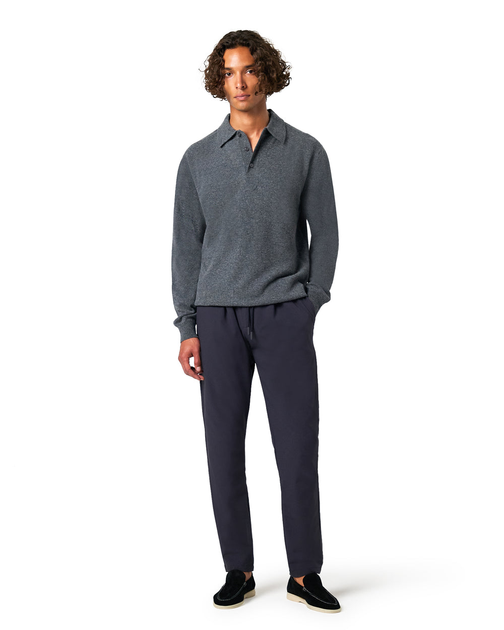 Man wearing a gray sweater and dark pants 