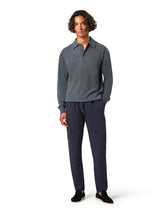 Man wearing a gray sweater and dark pants 