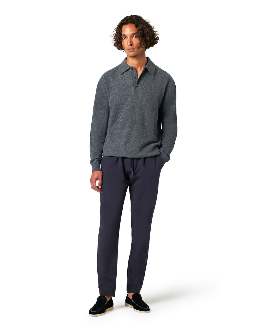 Man wearing a gray sweater and dark pants 