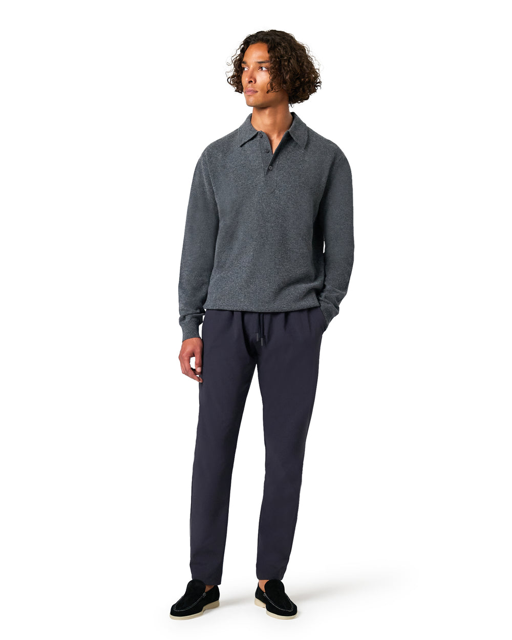 Man wearing a gray sweater and dark pants 