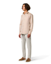 Man wearing a beige shirt and light gray pants