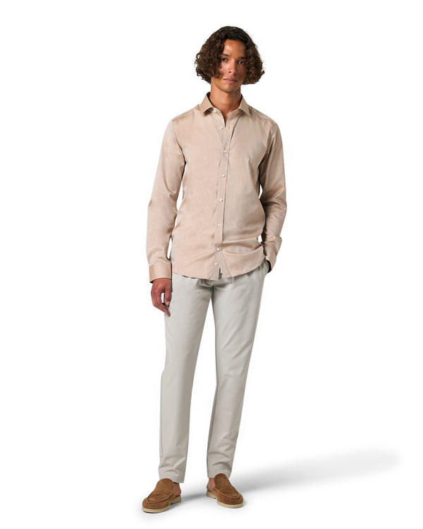 Man wearing a beige shirt and light gray pants 