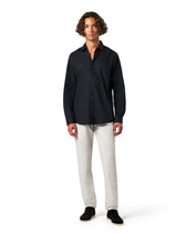 Man wearing a black shirt and white pants 