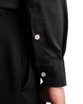 Close-up of a black shirt with buttons on a black background