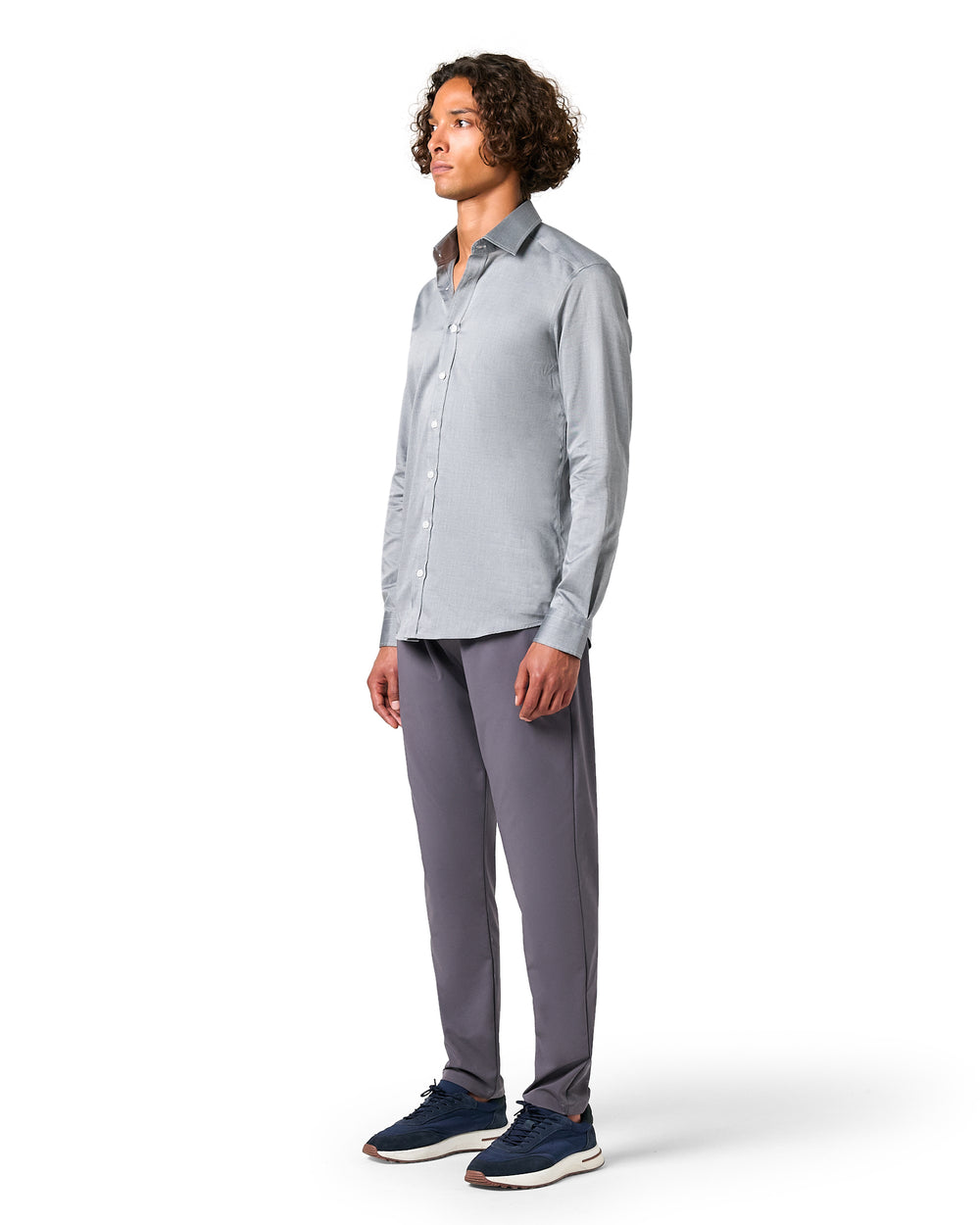 Man wearing a light gray button-up shirt and dark gray pants 