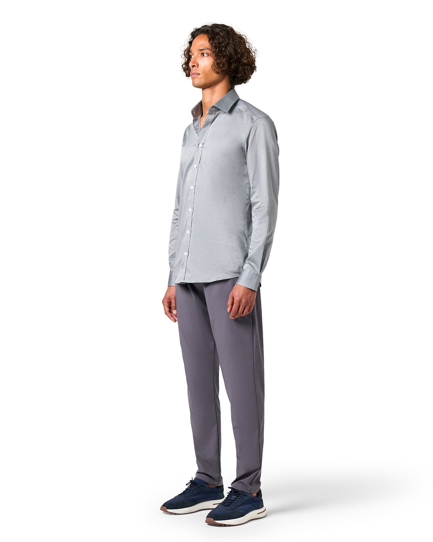 Man wearing a light gray button-up shirt and dark gray pants 