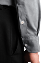 Close-up of a gray shirt with rolled-up sleeves on a black background