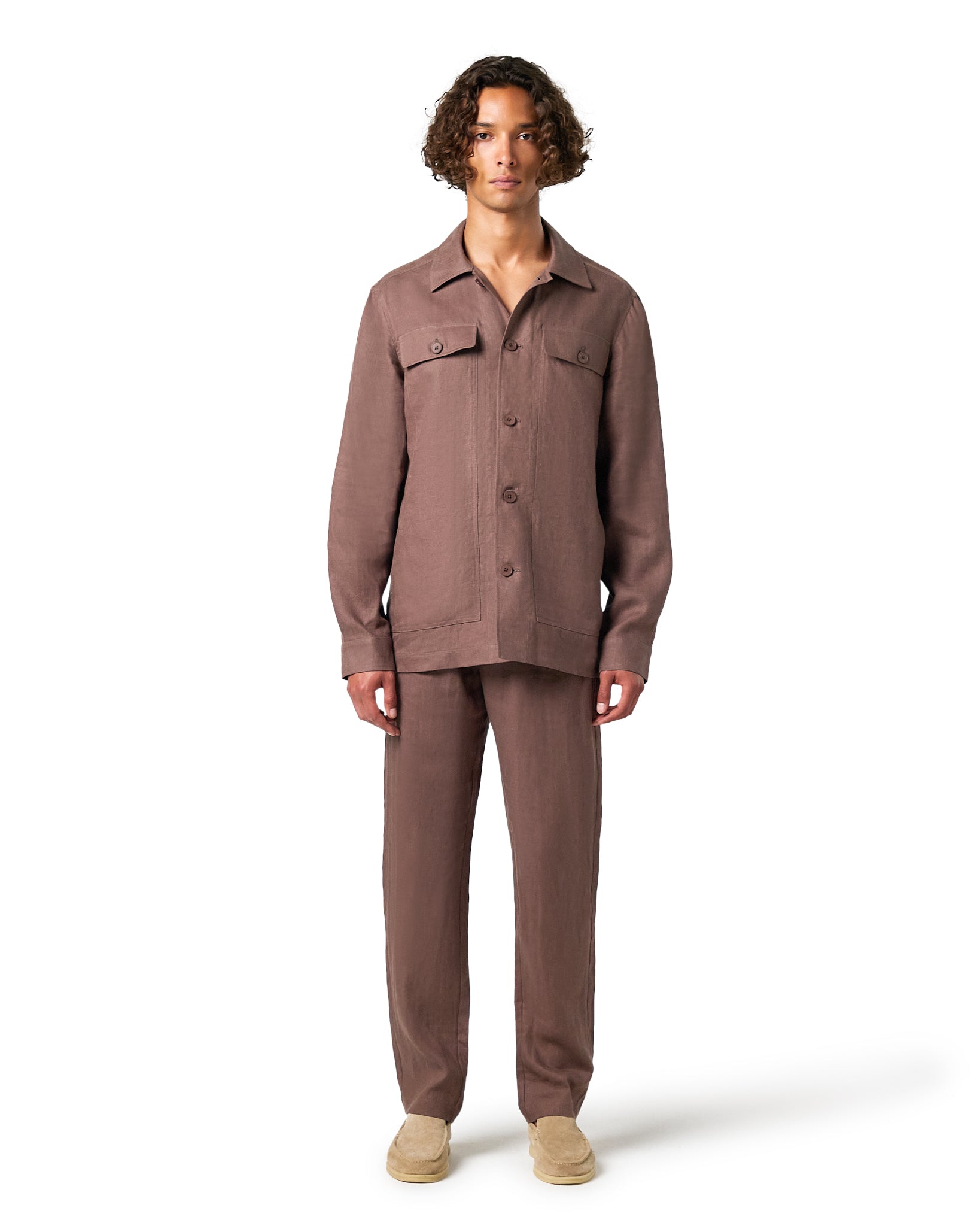 Man wearing a brown jacket and pants on a white background
