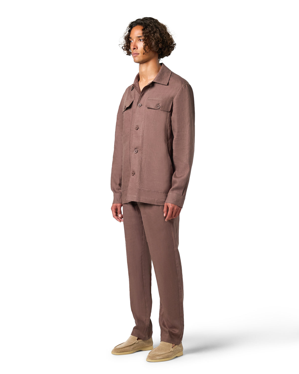 Man wearing a brown button-up shirt and pants on a white background
