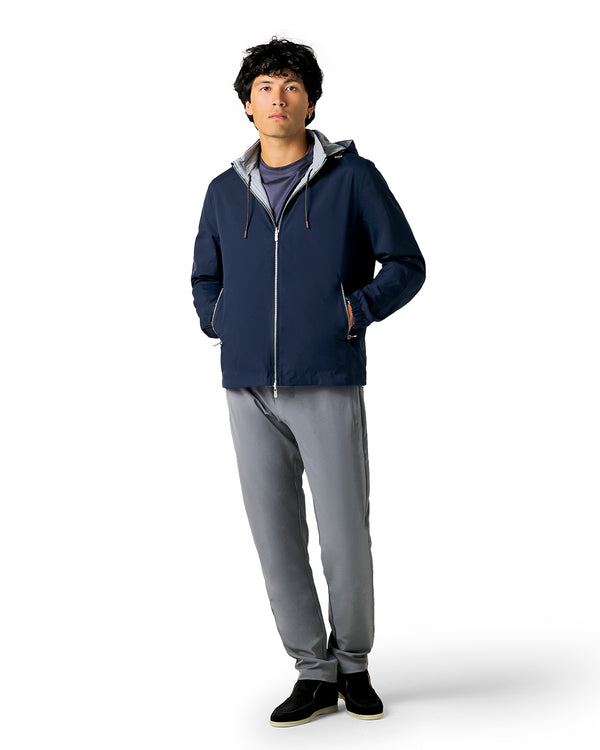 Person wearing a navy blue jacket and gray pants
