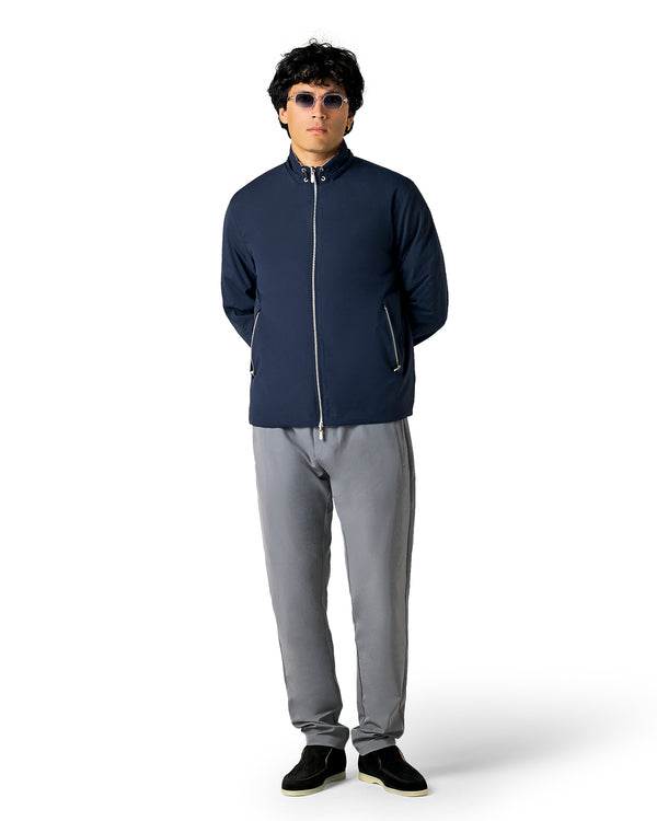 Person wearing a navy jacket and gray pants 