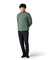 Man wearing a green jacket and black pants 
