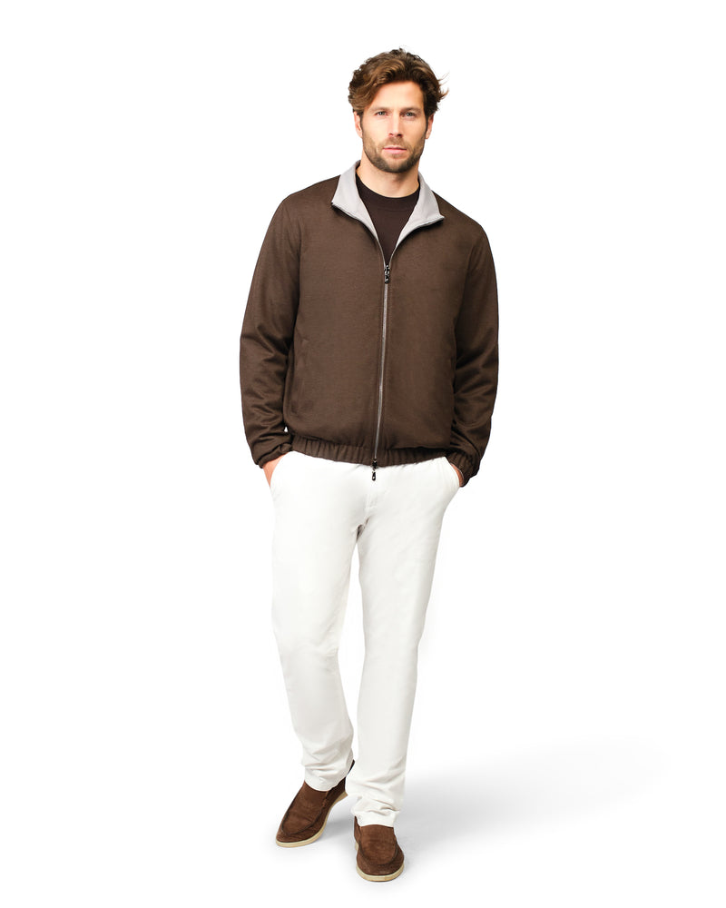 Man wearing a brown jacket and white pants 
