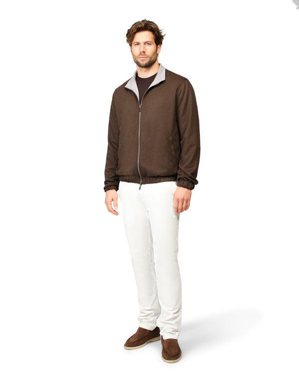 Man wearing a brown jacket and white pants 