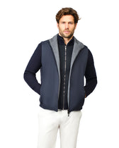 Man wearing a navy blue vest with gray hood on a white background