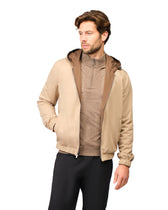 Man wearing a beige jacket with a hood on a white background