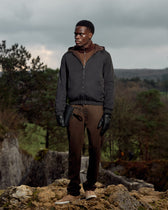 Man standing on a rocky outcrop with a forest background