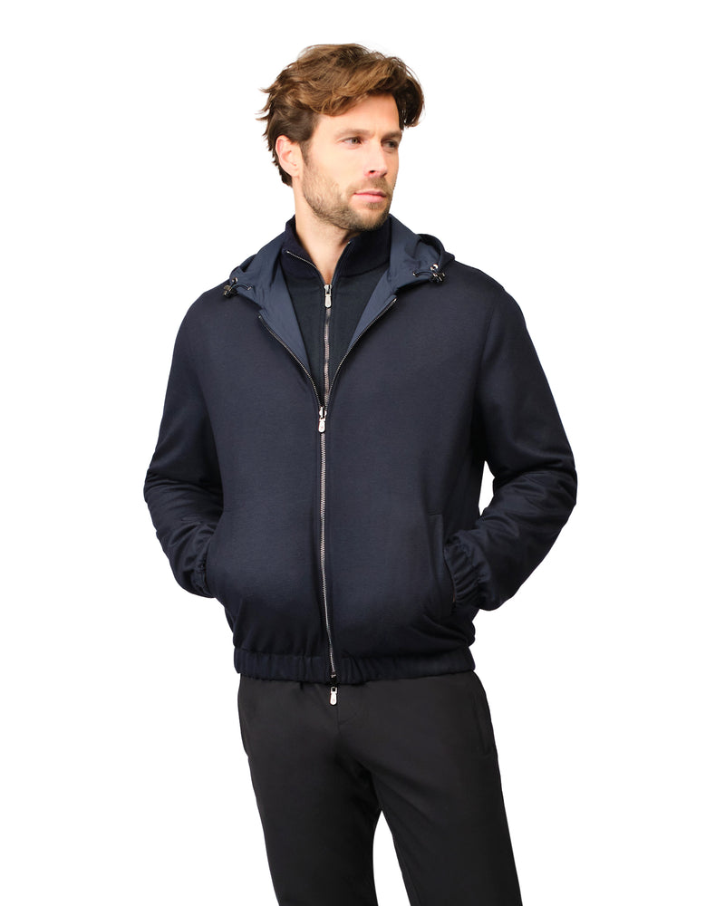 Man wearing a dark blue jacket with a hood on a white background