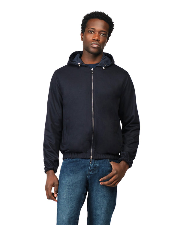 Man wearing a navy blue jacket with a hood on a white background