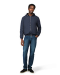 Man wearing a navy blue jacket and jeans on a white background
