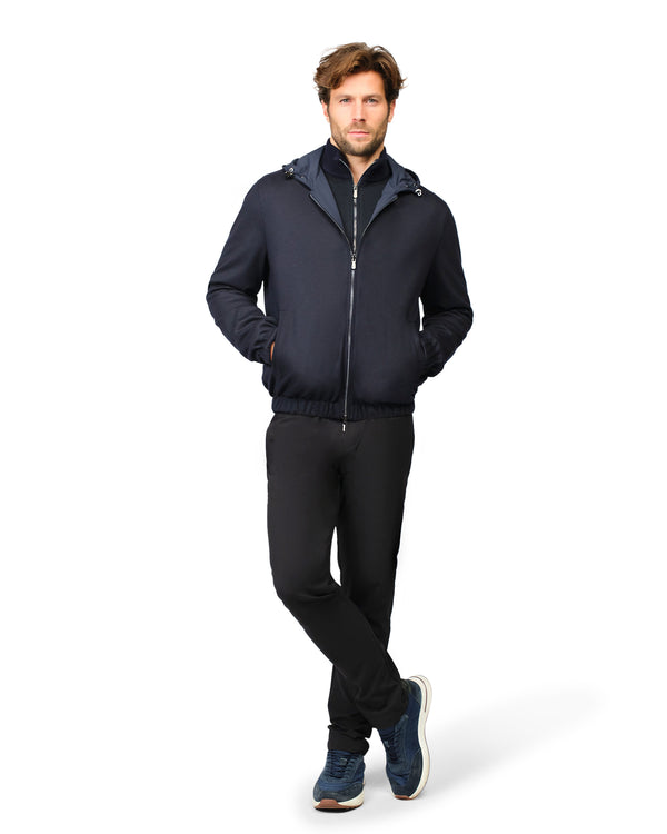 Man wearing a navy blue jacket and pants on a white background