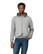 Man wearing a gray hoodie and blue jeans on a white background