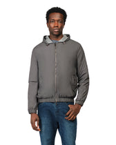 Man wearing a gray jacket with a hood on a white background