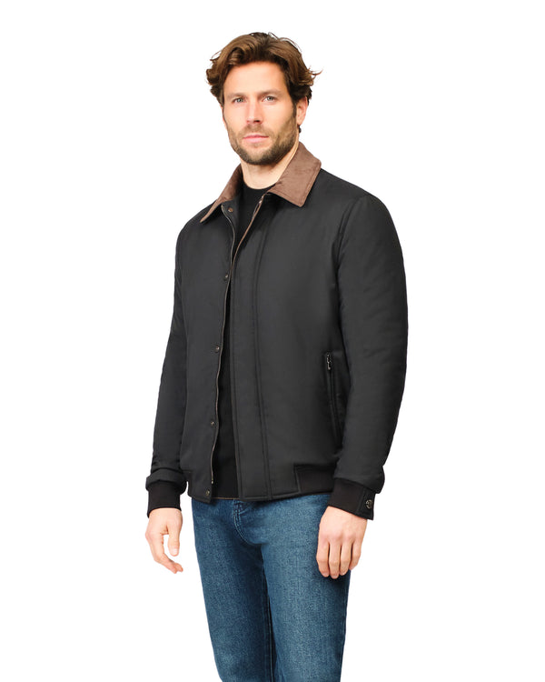 Man wearing a black jacket with a brown collar on a white background