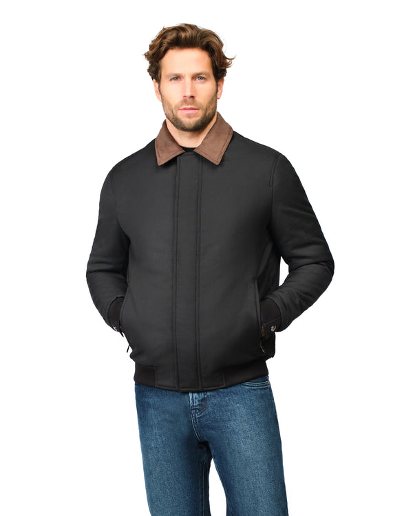 Man wearing a black jacket with a brown collar on a white background