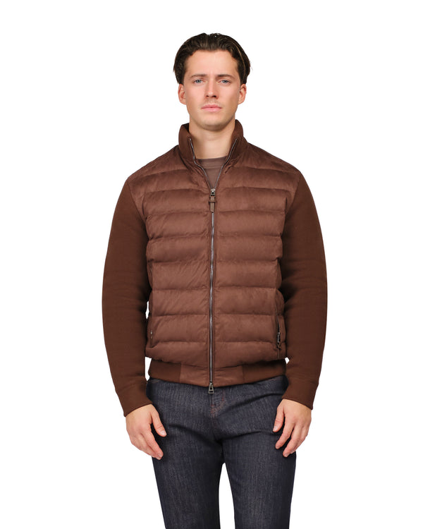 Man wearing a brown puffer vest over a sweater on a white background