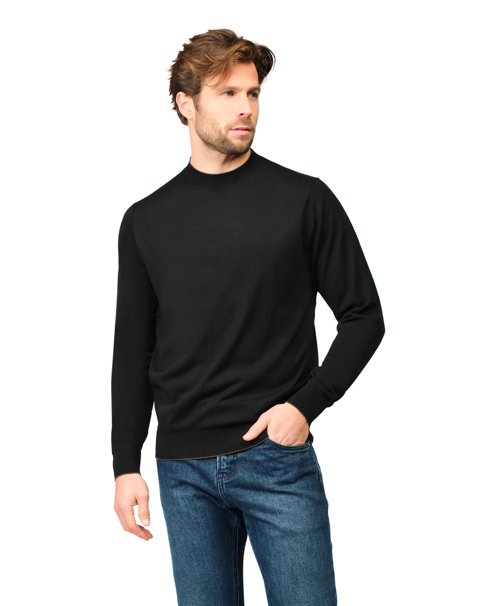 Man wearing a black sweater and blue jeans on a white background