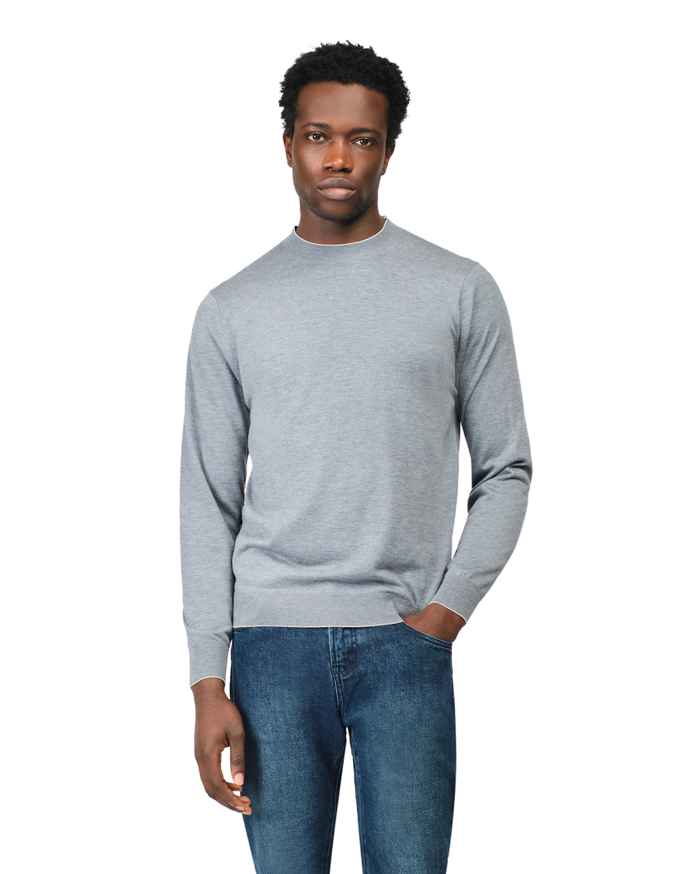 Man wearing a gray sweater and blue jeans on a white background