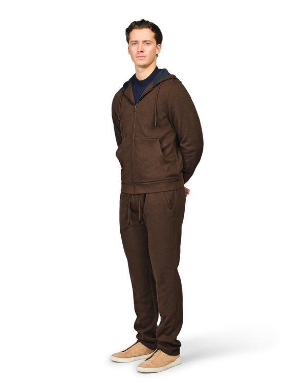 Man wearing a brown tracksuit on a white background